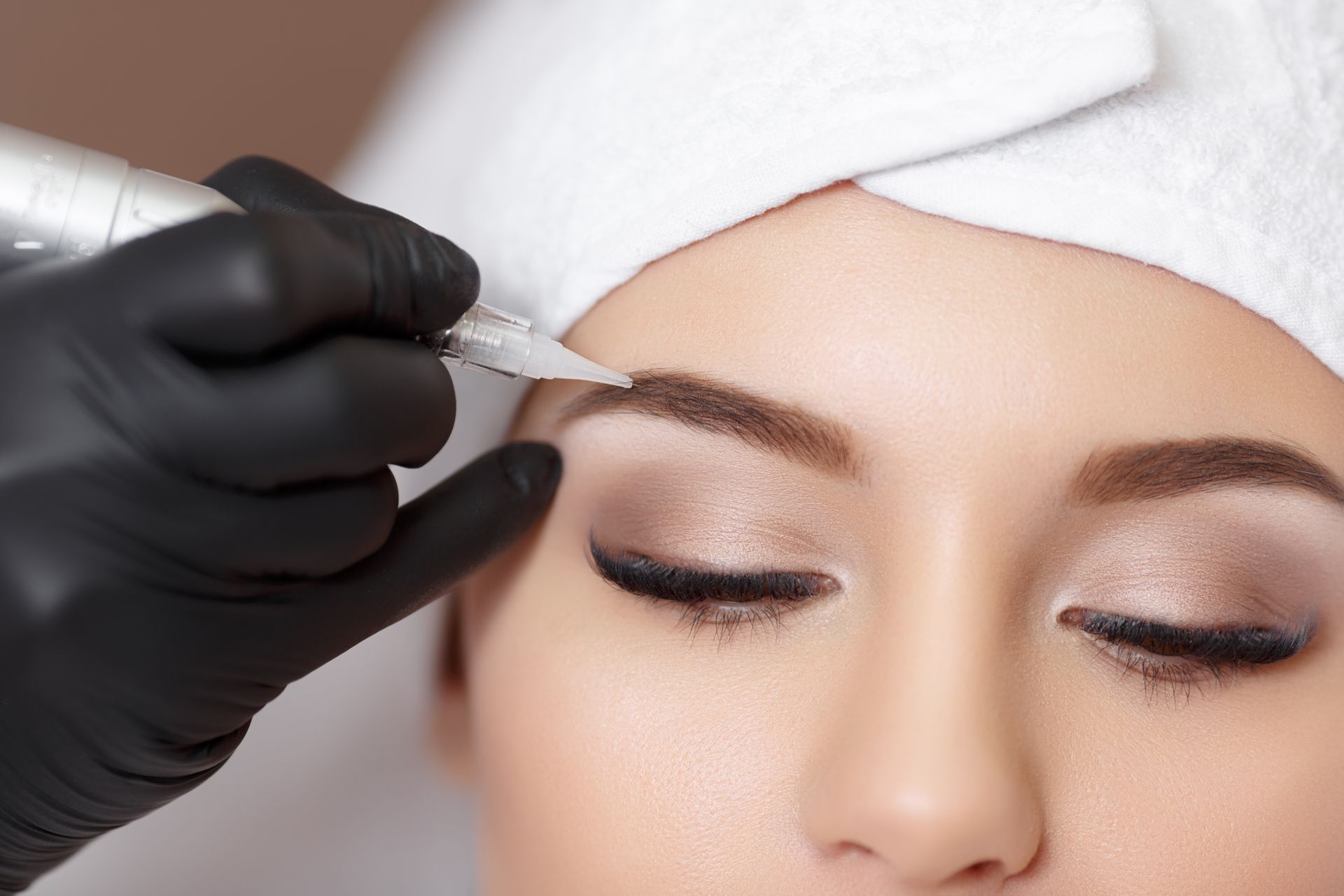 Permanent makeup. Permanent tattooing of eyebrows. Cosmetologist applying permanent make up on eyebrows- eyebrow tattoo